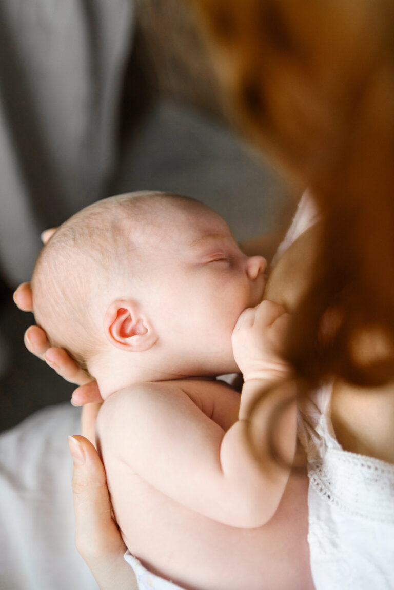 Ein Säugling wird an der Brust seiner Mutter gestillt